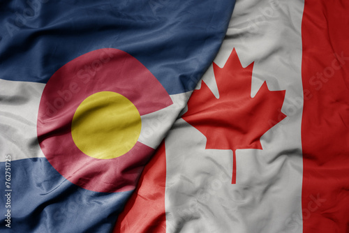 big waving realistic national colorful flag of colorado state and national flag of canada .