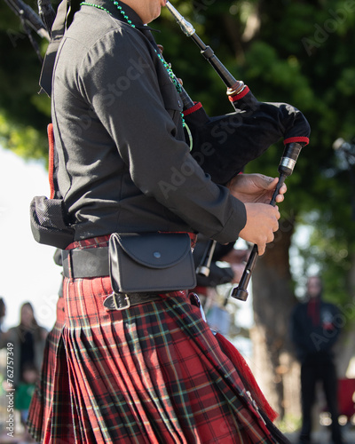 Bag pipe player wearing a kilt in honor of the Irish tradition during the St Patricks Day parade © motionshooter
