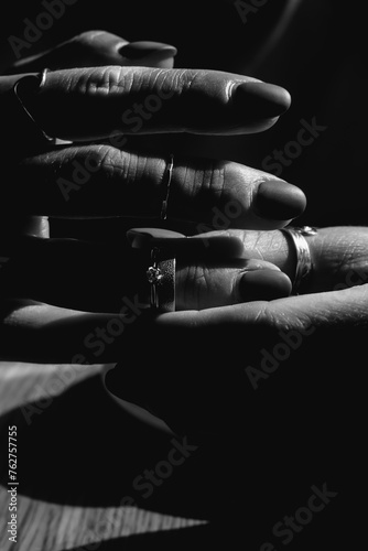 Black and white close-up of women's fingers with stylish silver and white gold jewelry. Concept of wealth, relationships, marriage, emotions, and stress.