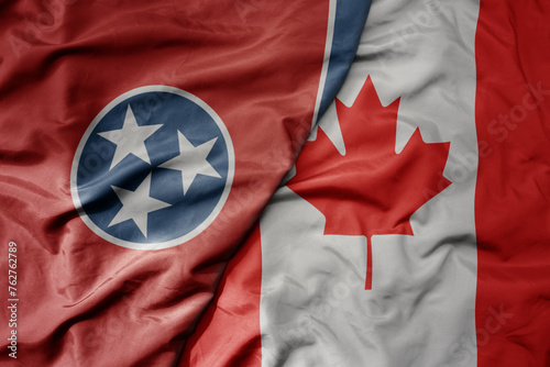 big waving realistic national colorful flag of tennessee state and national flag of canada .