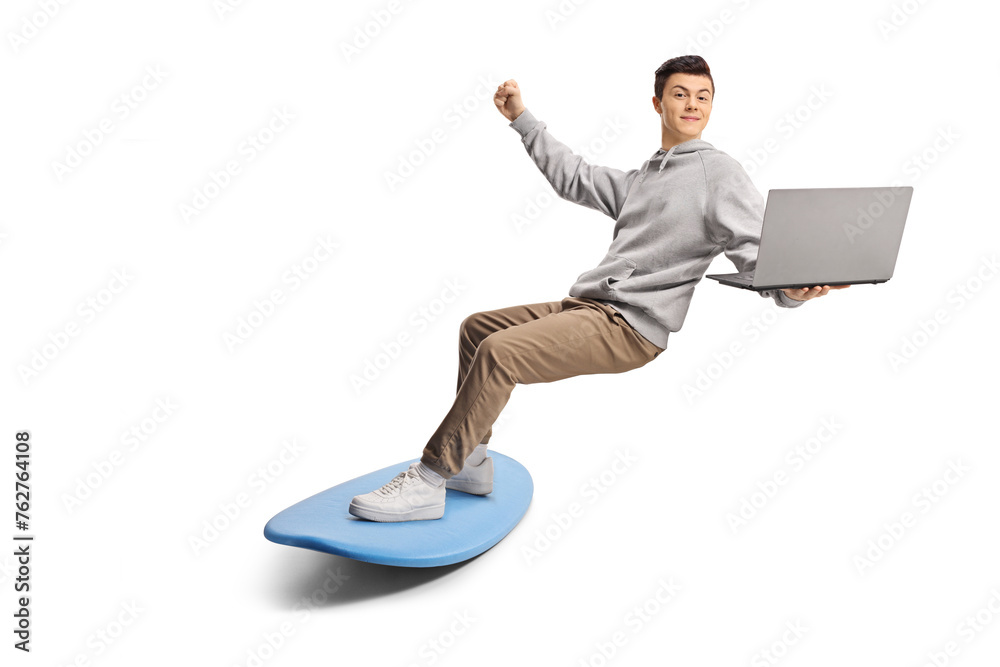 Young man surfing on a surfboard and holding a laptop computer Young man surfing on a surfboard and holding a laptop computer