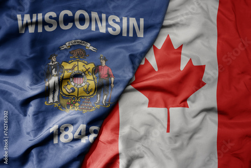 big waving realistic national colorful flag of wisconsin state and national flag of canada .
