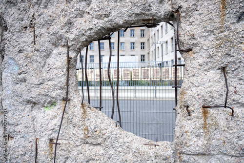 Photography This photograph captures a close-up view of a hole in a remaining section of the Berlin Wall