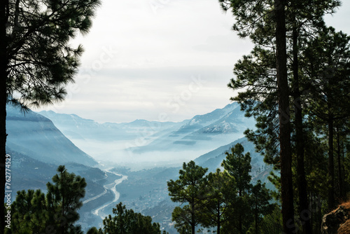 Amazing sunny view on Beas river in Kullu (Himachal Pradesh) with pine trees and town photo