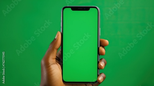 An African-American Woman uses her smart phone with her fingers that shows a green screen on the screen and background for creative to insert their products.
 photo