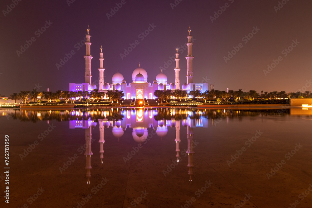 Fototapeta premium Night view of Sheikh Zayed Grand Mosque in Abu Dhabi reflecting in a water, United Arab Emirates.