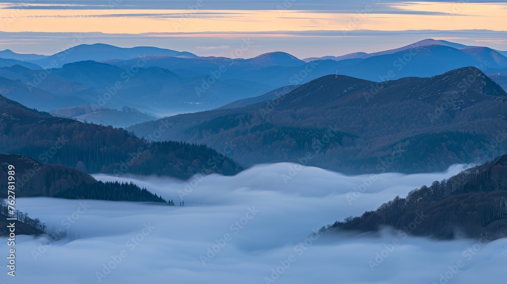 a view of a mountain range with low lying clouds in the foreground and low lying clouds in the foreground.