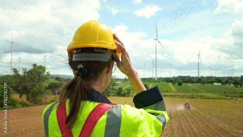A smart engineer is putting a protective helmet on head at electrical turbines field
