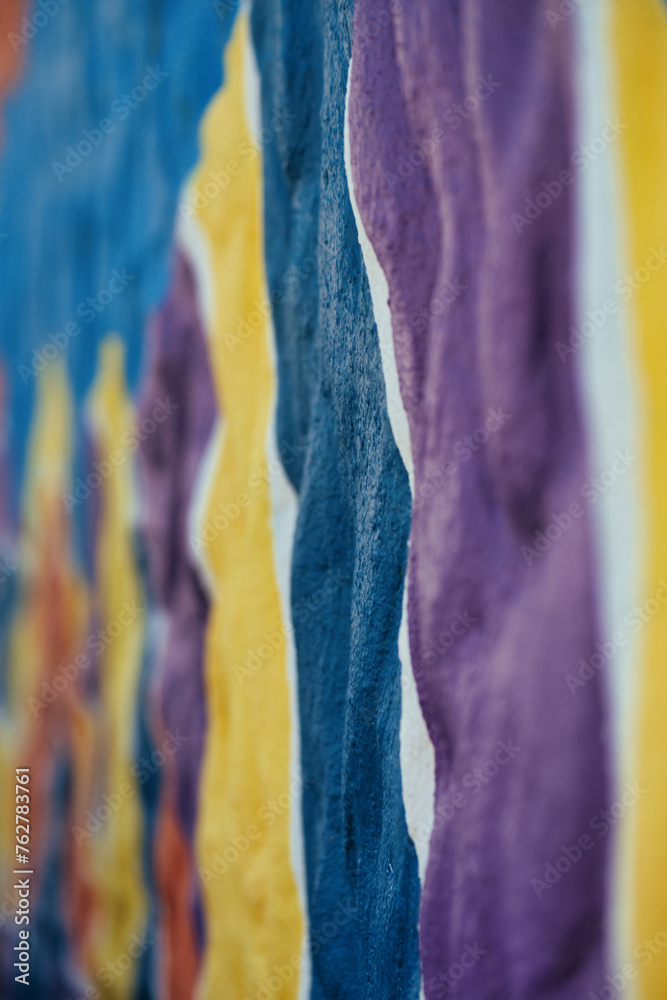Close up of vibrant blue, purple, and yellow brush strokes on canvas for artistic backgrounds