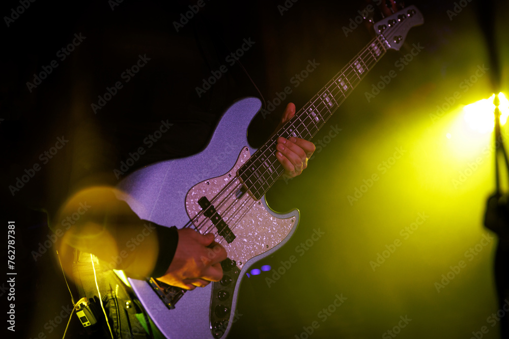 Obraz premium Bass guitarist playing live concert with rock band
