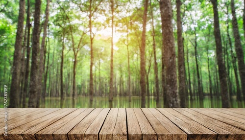 green nature with woodden table top blur morning light forest for montage products display advertising background