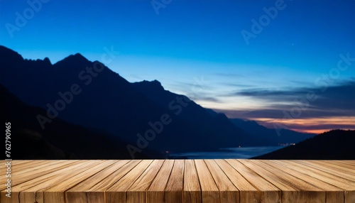 empty wooden desk and night scenery with a mountains on background