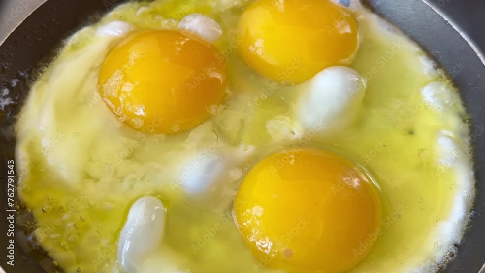 Three eggs in a frying pan with olive oil Three eggs in a frying pan with olive oil
