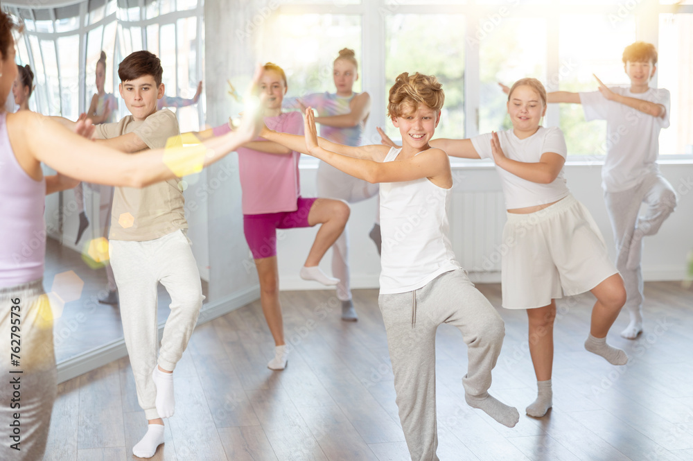 Fototapeta premium Group of boys and girls rehearsing dancehall dance in studio