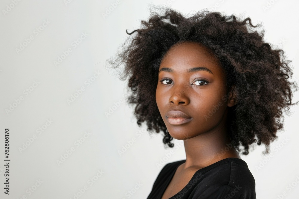 A woman with curly hair is standing in front of a white background A woman with curly hair is standing in front of a white background