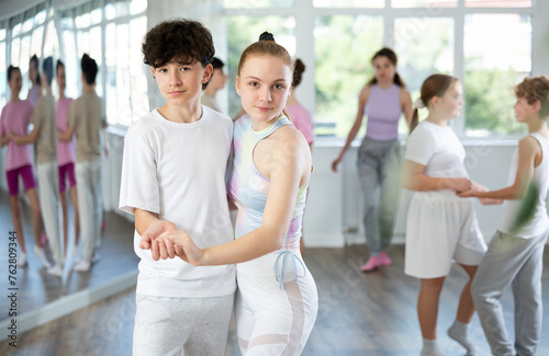 Group of positive teenagers learning to dance tango in a dance studio