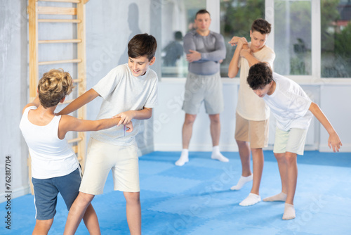 Sedulous underage practitioner of self-defense courses applying attack methods on his opponent