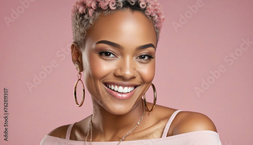 Portrait of African American woman with short hair smiling and wearing earrings on pink isolated background