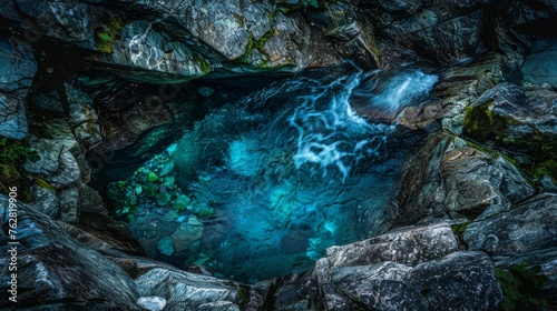a pool of water surrounded by rocks and greenery in the middle of the picture is lit by the light of a lantern.
