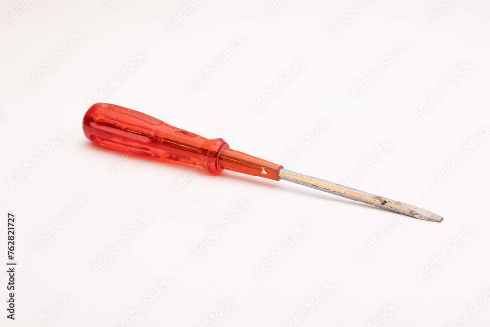 Fototapeta premium Red handled screwdriver with a metallic tip on a white background.