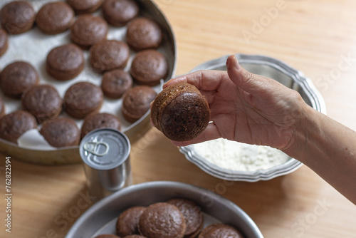 Pães de mel recheados com doce de leite sendo preparados para o banho de chocolate e recheio de doce de leite photo