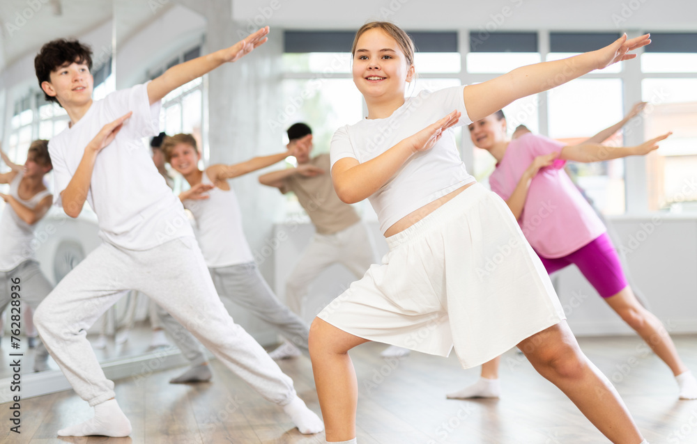 Fototapeta premium Group of boys and girls rehearsing hip hop dance in studio