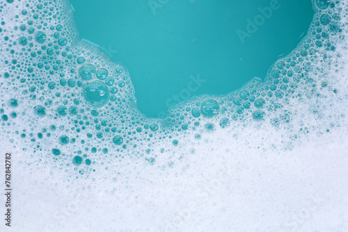 Detergent foam bubble on water. Blue background, Soap sud photo