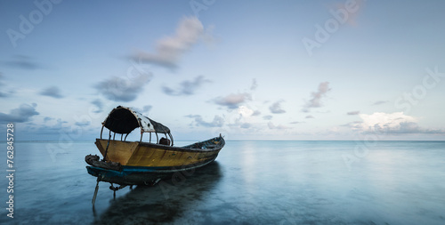 Traditional fishermen boat at the coast of Havelock island in Andaman islands archipelago at sunset photo