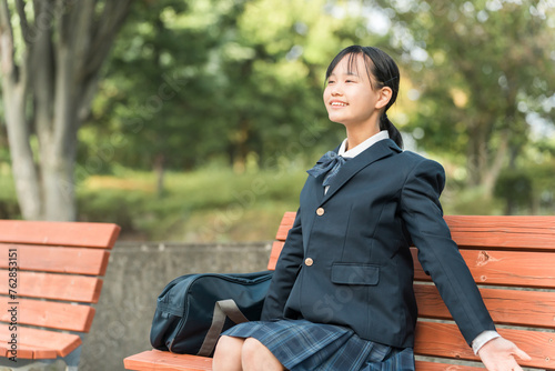 公園のベンチに座り深呼吸する女子中学生・女子高生・高校生
