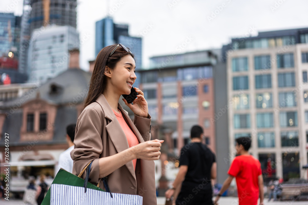 Asian beautiful women talking on phone while walk in department store. 