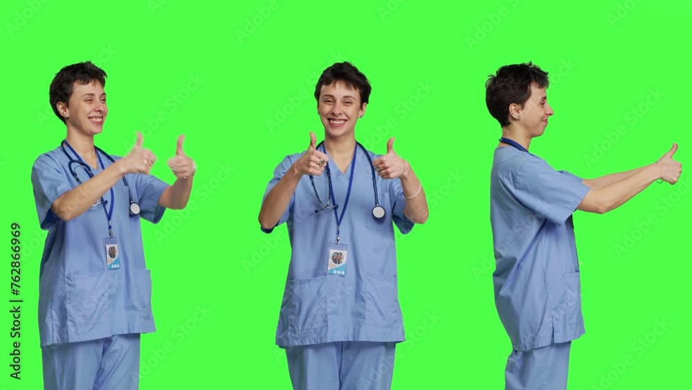 Cheerful nurse giving thumbs up sign against greenscreen backdrop, showing positive gesture with a like. Medical assistant shows her approval, recommending something and being satisfied. Camera B. Cheerful nurse giving thumbs up sign against greenscreen backdrop, showing positive gesture with a like. Medical assistant shows her approval, recommending something and being satisfied. Camera B.