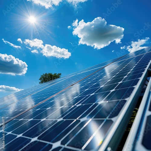 Solar panels with sun and clouds in the sky - Green energy represented through gleaming solar panels under a clear sky with sun and clouds
