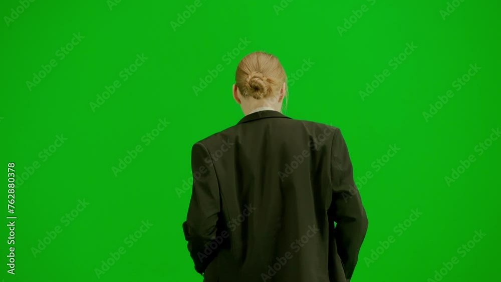 Portrait of female in suit on chroma key green screen. Blonde business woman in formal outfit walking and dancing. Back view. Portrait of female in suit on chroma key green screen. Blonde business woman in formal outfit walking and dancing. Back view.