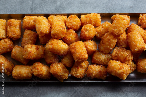 A top down view of a tray full of deep fried tater tots. photo