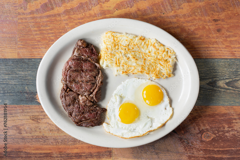A top down view of a plate of steak and eggs.