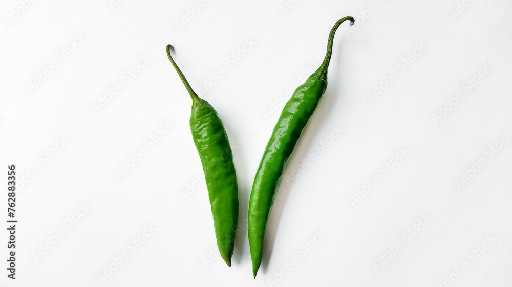 Two fresh green chili peppers isolated on a white background with ample space for text, ideal for culinary themes and spicy food concepts Two fresh green chili peppers isolated on a white background with ample space for text, ideal for culinary themes and spicy food concepts