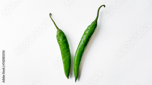 Two fresh green chili peppers isolated on a white background with ample space for text, ideal for culinary themes and spicy food concepts