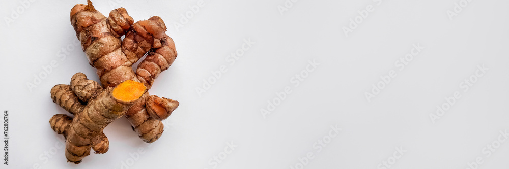 Fresh turmeric roots on a clean white background with copy space, perfect for health and wellness concepts Fresh turmeric roots on a clean white background with copy space, perfect for health and wellness concepts