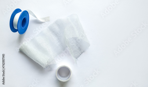Cuadro en lienzo Medical bandage roll with blue dispenser and adhesive tape on a white background