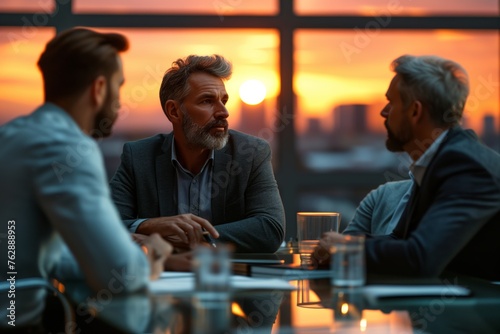 Group of Caucasian men brainstorming, Executives converse at sunset, vivid orange hues backdrop, intense exchange, middle-aged man with beard engages colleagues. Senior professionals discuss