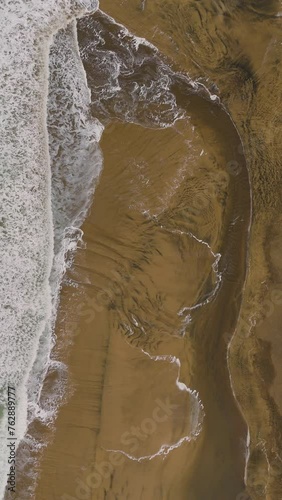 Waves crashing into the sand with great patterns photo