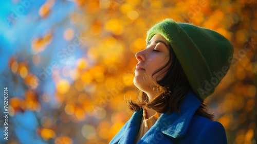 Calm girl in blue coat and green hat and coat closing eyes while spending sunny day on blurred background of autumn park in a cold day in donostia san sebastian spain : Generative AI photo