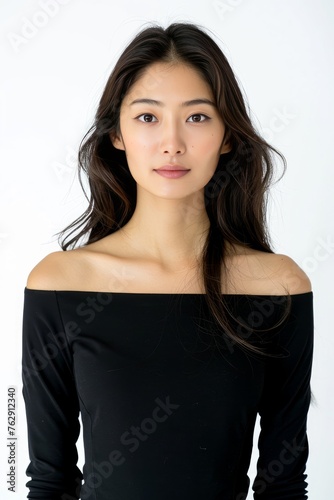 Portrait of a pretty young woman super model of Korean ethnicity wearing a chic and sophisticated black sheath dress with a boat neckline, three-quarter sleeves, and subtle embellishments © Aditya