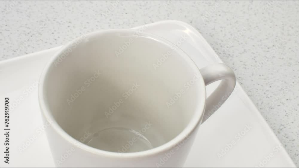 Close-up of a white porcelain cup at rest on a light surface, inviting contemplation. Close-up of a white porcelain cup at rest on a light surface, inviting contemplation.