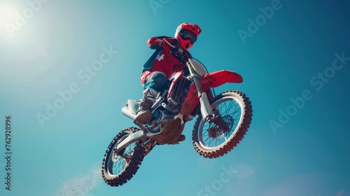 Motocross rider in midair against clear blue sky  displaying skill and precision