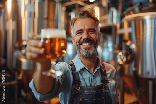 Experienced brewer in denim apron offering a pint of craft beer, expressing craftsmanship and enjoyment, Concept of craft brewing, small business, and artisanal skill