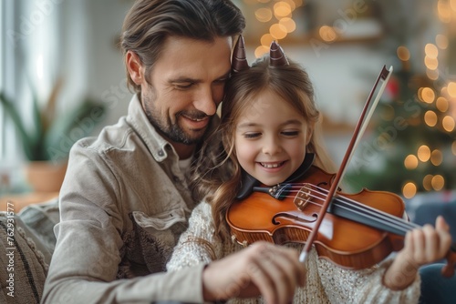 Father teaching young daughter to play violin at home, concept of family bonding and music education