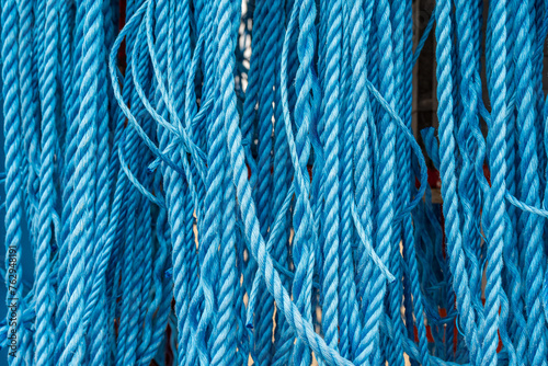background close up of industrial blue ropes hanging vertically