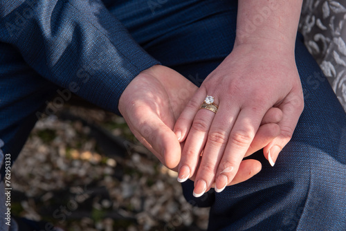 The groom holds the bride's hand. Newly wed couple's hands with wedding rings ,in Romania