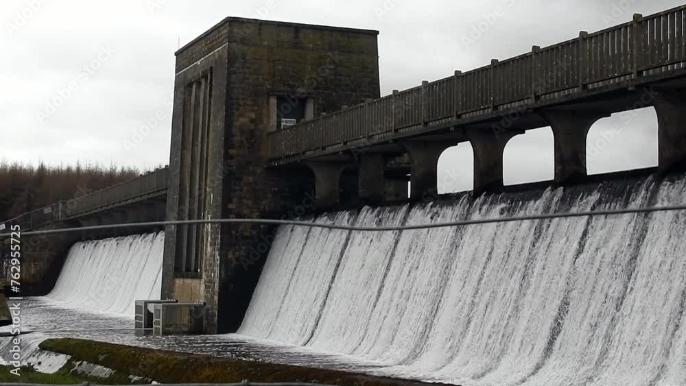 Llyn Cefni reservoir concrete dam gate pouring from Llangefni lagoon, Anglesey rural scene Llyn Cefni reservoir concrete dam gate pouring from Llangefni lagoon, Anglesey rural scene